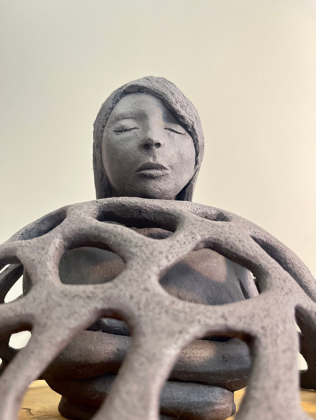 Armour sculpture, dark stoneware figure inside a latticed dome, eyes closed — view 3