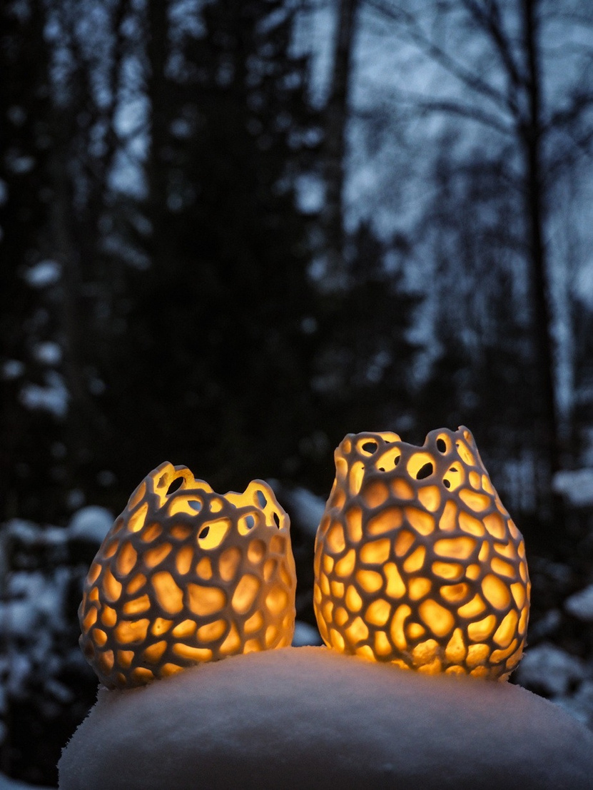 Aurora porcelain vessels, small cluster of pale glazed pieces with carved lattice surfaces, light passing through — view 2