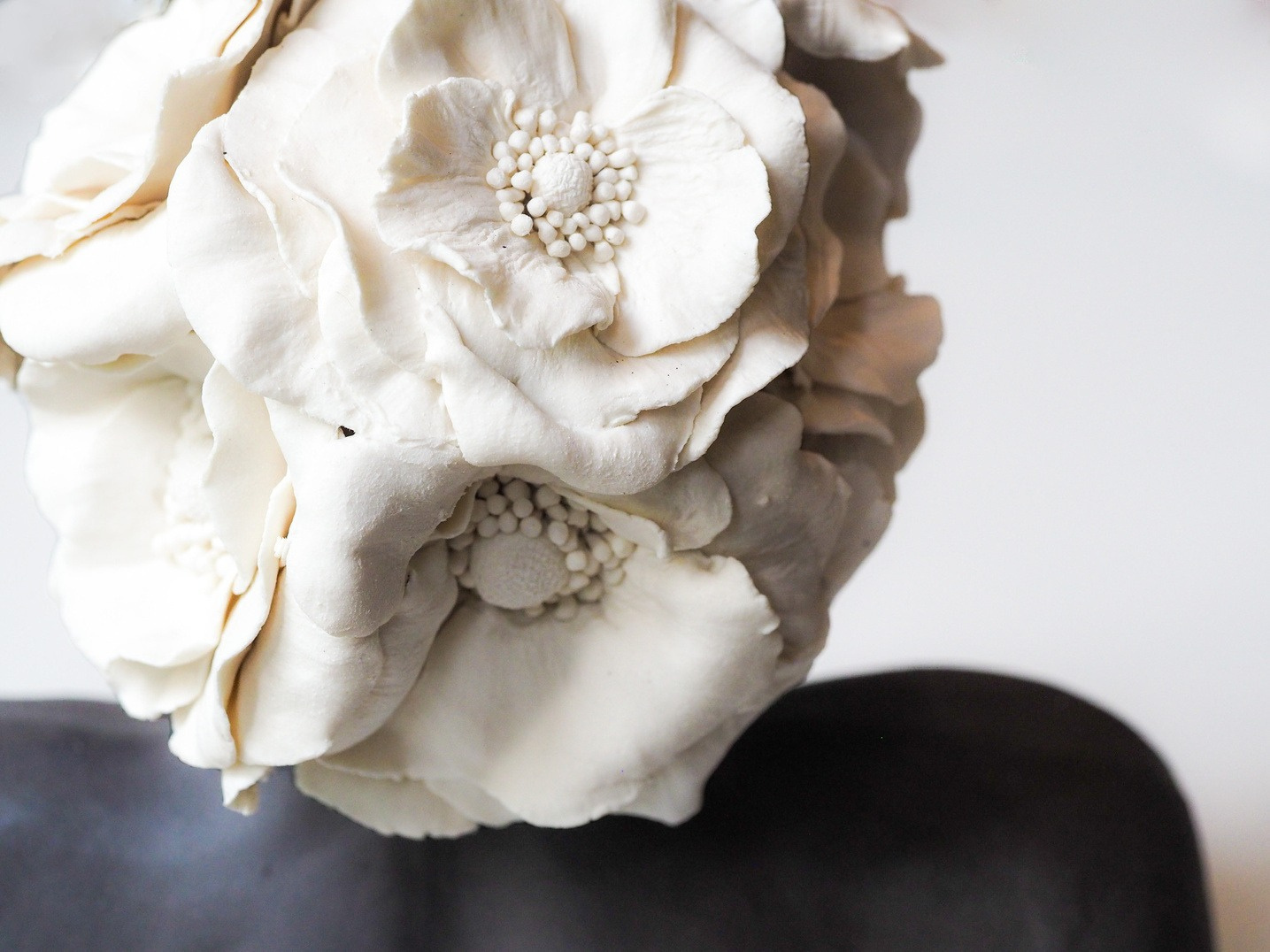 Azra bust, dark stoneware figure with a crown of large white porcelain roses, eyes closed — view 3
