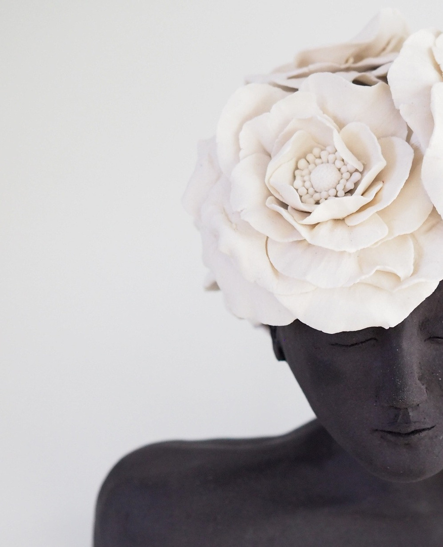 Azra bust, dark stoneware figure with a crown of large white porcelain roses, eyes closed