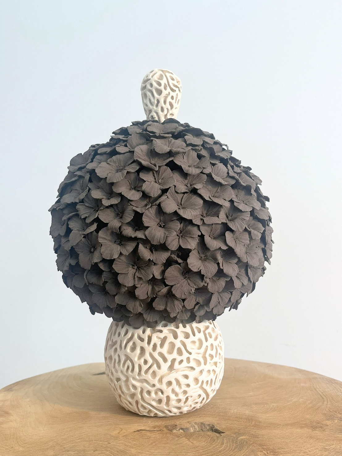 Tear on the Danube sculptural form, compact sphere with alternating dark stoneware petals and pale carved lace-like base