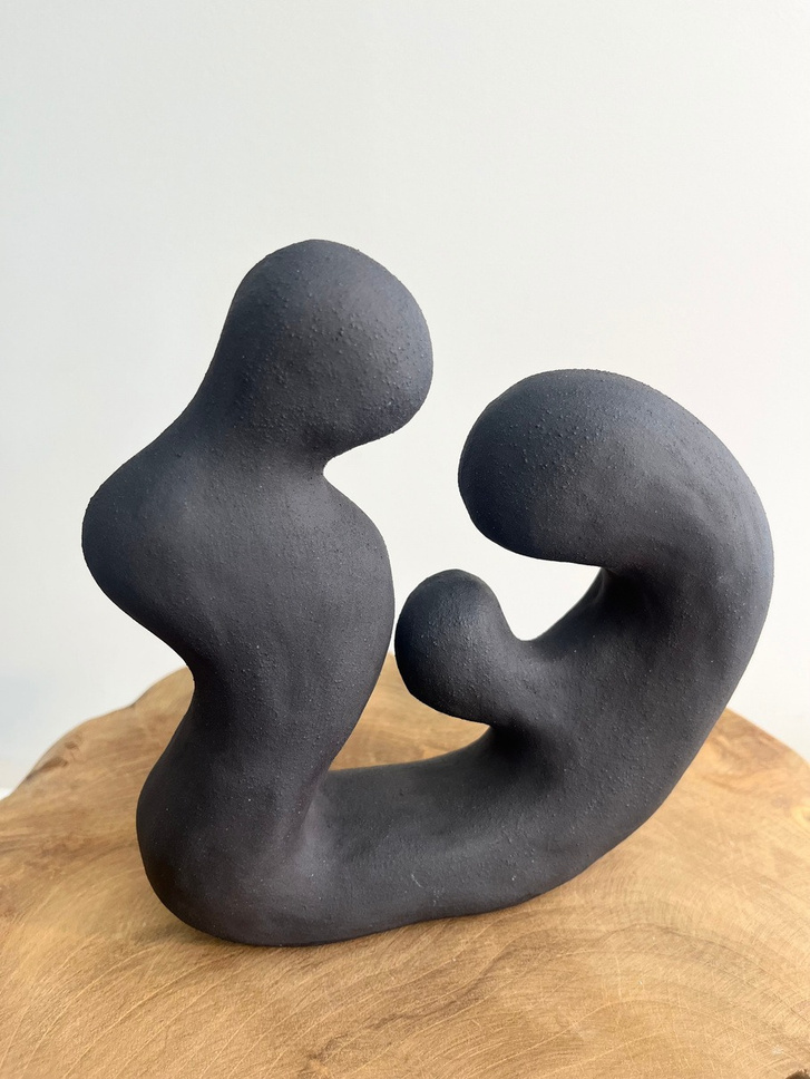The shape of Us sculpture, two dark stoneware forms leaning into each other, smooth organic surfaces